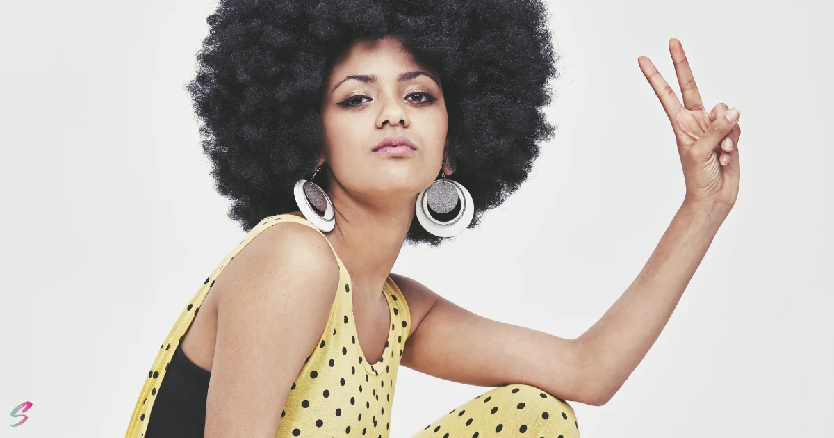 Femme avec coupe afro vintage incarnant les coupes inspirées des années 70 à Paris
