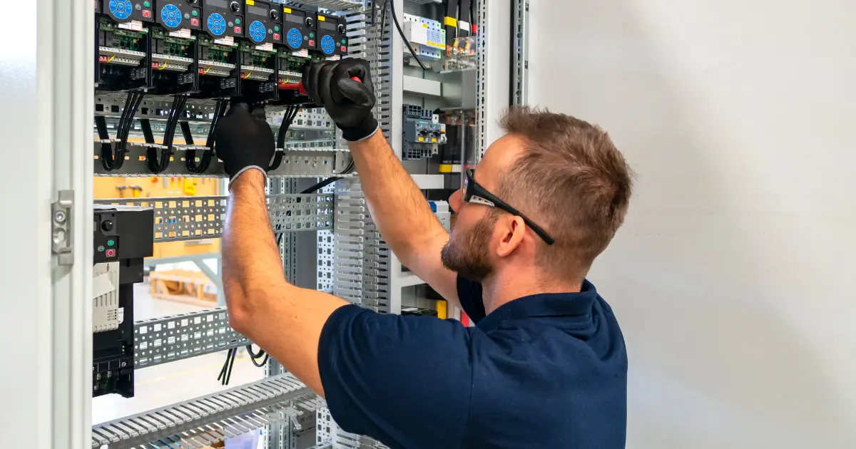 Électricien indépendant installant un tableau électrique en France.